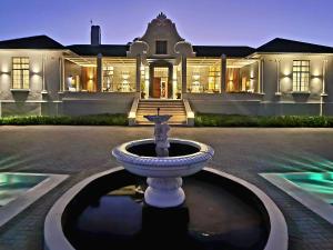 a large white mansion with a fountain in front of it at PJURE Boutique Hotel & Spa in Montagu