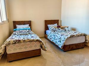 - deux lits assis l'un à côté de l'autre dans une pièce dans l'établissement Your new home, à Oujda