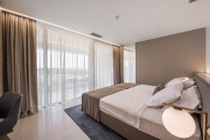 a bedroom with a bed and a large window at Aparthotel Joel in Novalja