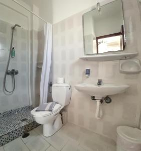 a bathroom with a toilet and a sink and a mirror at Horizon Resort in Kamari