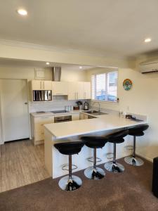 a kitchen with a large island with bar stools at Roslyn Sanctuary Hereford St Dunedin in Dunedin