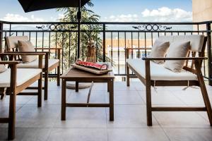 a balcony with two chairs and a table and an umbrella at ANNO Apartment Imotski-Makarska in Imotski