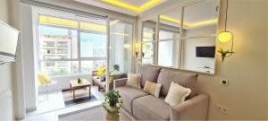 a living room with a couch and a large window at ESTEPONA RADA BEACH ABC APARTMENTS & ESTUDIOS A in Estepona