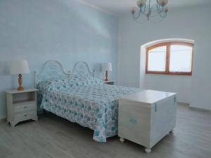 una camera da letto con un letto con un piumone blu e una finestra di GOCCE DI MARE a Cala Gonone