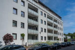 an apartment building with cars parked in front of it at Apartamenty MM - Rzeźniczaka in Zielona Góra