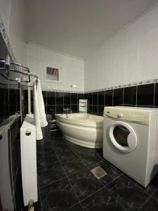 a bathroom with a washing machine and a bath tub at Casa Carmen in Tîrgu Ocna