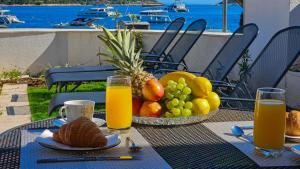 uma mesa com uma cesta de frutas e sumo de laranja em Villa Mar a Mar em Vis