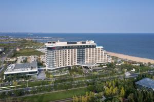 an aerial view of a hotel near the ocean at Qinhuangdao Marriott Resort in Qinhuangdao
