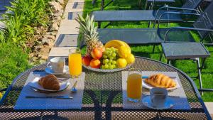 uma mesa com uma cesta de frutas e sumo de laranja em Villa Mar a Mar em Vis