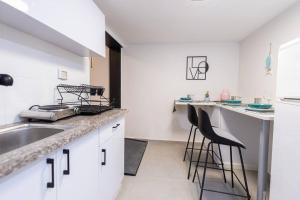 una cucina con lavandino e 2 sgabelli da bar di O&O Group - The SeaGate Estate suites - Suite 3 a Rishon LeẔiyyon
