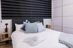una camera da letto con un letto bianco e asciugamani di O&O Group - The SeaGate Estate suites - Suite 3 a Rishon LeẔiyyon
