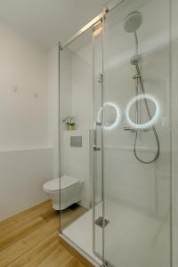 a bathroom with a glass shower with a toilet at Apartamenty MM - Rzeźniczaka in Zielona Góra