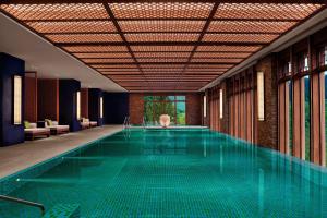 a swimming pool in a building with a large pool at Rissai Valley, a Ritz-Carlton Reserve in Jiuzhaigou