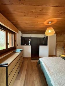 a bedroom with a bed and a window and a kitchen at Chalet Le petit paradis - Chamonix-Mont-Blanc in Chamonix