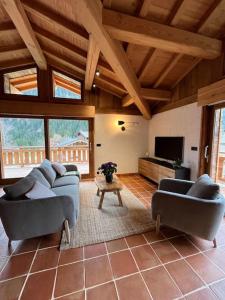 uma sala de estar com dois sofás e uma televisão em Chalet Le petit paradis - Chamonix-Mont-Blanc em Chamonix-Mont-Blanc