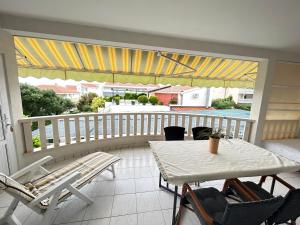patio con mesa y sillas en el balcón en Apartments Sanda, en Promajna