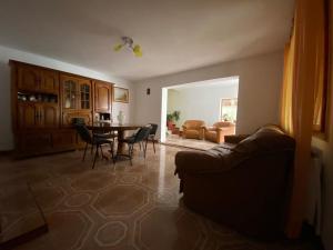a living room with a couch and a table and chairs at Casa Carmen in Tîrgu Ocna +30 photos