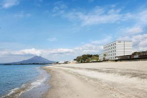 Blick auf den Strand mit einem Gebäude im Hintergrund in der Unterkunft Fairfield by Marriott Kagoshima Sakurajima in Tarumizu