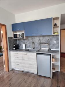 a kitchen with blue cabinets and a sink at Complex Astra in Sunny Beach