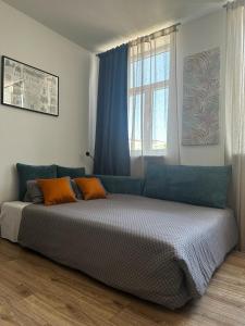 1 dormitorio con 1 cama grande con almohadas de color naranja en Like-a House Centrum en Płock