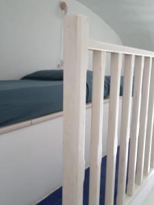 ein weißes Kinderbett mit einer blauen Decke drauf in der Unterkunft Agenzia Isotur La Magnolia in Ponza