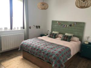 a bedroom with a large bed with a green headboard at CASA NATURAE in Pineda de la Sierra