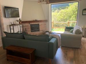 a living room with a couch and a fireplace at CASA NATURAE in Pineda de la Sierra