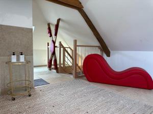 un sofá rojo en una habitación con escalera en L'évasion-SPA-Hammam-Sauna Illimité - 2 à 4 pers en Saint-Cyr-sur-Loire