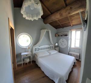 um quarto com uma cama branca e um relógio na parede em B&B L'Usignolo em Ascoli Piceno