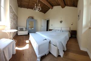 a bedroom with a large white bed and a table at B&B L'Usignolo in Ascoli Piceno
