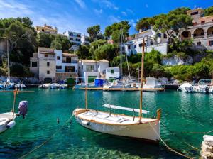 a boat is docked in the water in a harbor at HOSTAL RESTAURANTE CALA in Cala Figuera