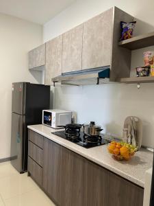 a kitchen with a stove and a bowl of fruit on the counter at 8 Pax Family 100Mbps Kepong DesaPark MontKiara Publika Mitec in Kuala Lumpur