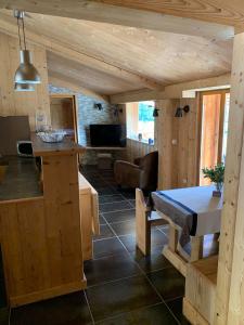 a kitchen and living room in a log cabin at LES BALCONS DU PHENY LE REFUGE in Gérardmer