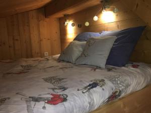 ein großes Bett mit einem Gemälde darauf in einem Zimmer in der Unterkunft LES BALCONS DU PHENY LE REFUGE in Gérardmer