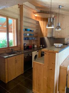 eine Küche mit Holzschränken, einer Spüle und einem Herd in der Unterkunft LES BALCONS DU PHENY LE REFUGE in Gérardmer