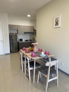 クアラルンプールにある8 Pax Family 100Mbps Kepong DesaPark MontKiara Publika Mitecのピンクの食器が並ぶテーブル付きのキッチン