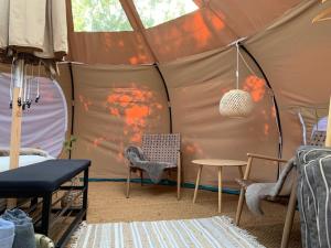 a tent with a table and chairs in a room at Romantic Luxus Glamping 3 in Idestrup