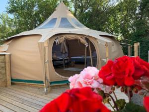 ein großes Zelt mit einer Terrasse mit Blumen davor in der Unterkunft Romantic Luxus Glamping 3 in Idestrup