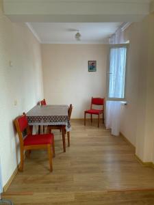 a dining room with a table and chairs and a window at Апартаменты Инал-ипа 10 in Sukhum