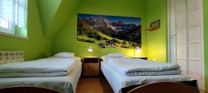 two beds in a room with green walls at DW Jastrun in Białka Tatrzanska
