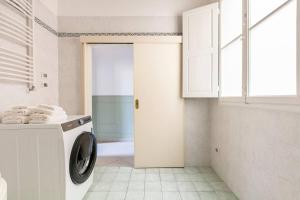 a white laundry room with a washing machine in it at Appartamento Sant'Ambrogio in Florence