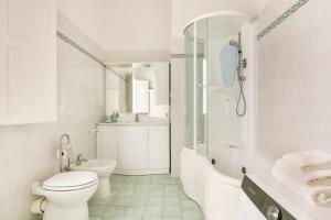 a white bathroom with a toilet and a tub and a sink at Appartamento Sant'Ambrogio in Florence