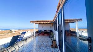 a room with a balcony with a view of the ocean at EL Faro Surfstay in Tamri