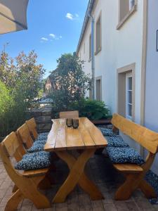 a wooden table and benches on a patio at Ferienwohnung am Wald-und Wiesenkorb in Kell