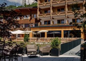 a hotel with chairs and tables in front of a building at Hotel Ferienalm in Schladming