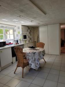 eine Küche mit einem Tisch und Stühlen im Zimmer in der Unterkunft Chambre d'Hôtes à Cestas in Cestas