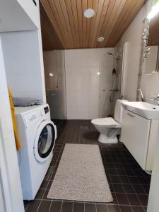a bathroom with a washing machine and a sink at Toppilansalmi two bedroom apartment with a view in Oulu