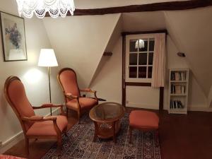 sala de estar con sillas, mesa y ventana en le clos Sainte Helene, en Glos-sur-Risle