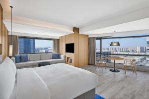 een hotelkamer met een groot bed en een bank bij Courtyard by Marriott Xiamen in Xiamen