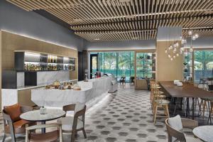 a restaurant with tables and chairs and a bar at Courtyard by Marriott Xiamen in Xiamen